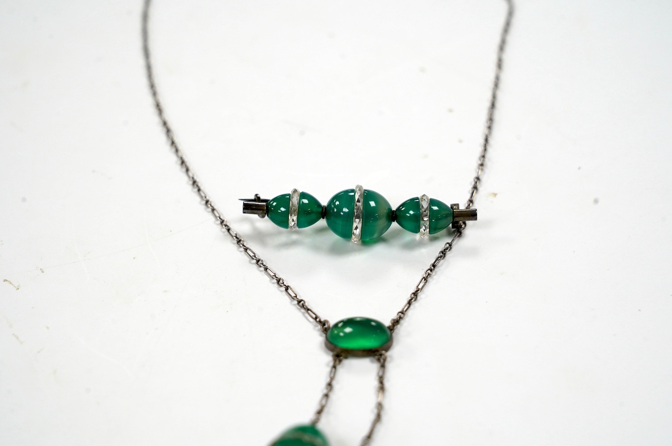 A white metal and green paste set double drop pendant necklace, 54cm and a similar brooch. Condition - fair to good